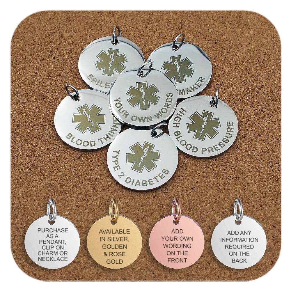 Collection of round metal medical alert pendants displayed on a corkboard featuring engraved medical symbols and text such as 'Epilepsy', 'Pacemaker', 'Blood Thinner', 'Type 2 Diabetes', 'High Blood Pressure', and 'Your Own Words' for custom engraving. Four additional pendants at the bottom show engraved text that reads: pendant or charm use, metal finishes in silver, gold, and rose gold, and the ability to add personalized wording on the front and back.
