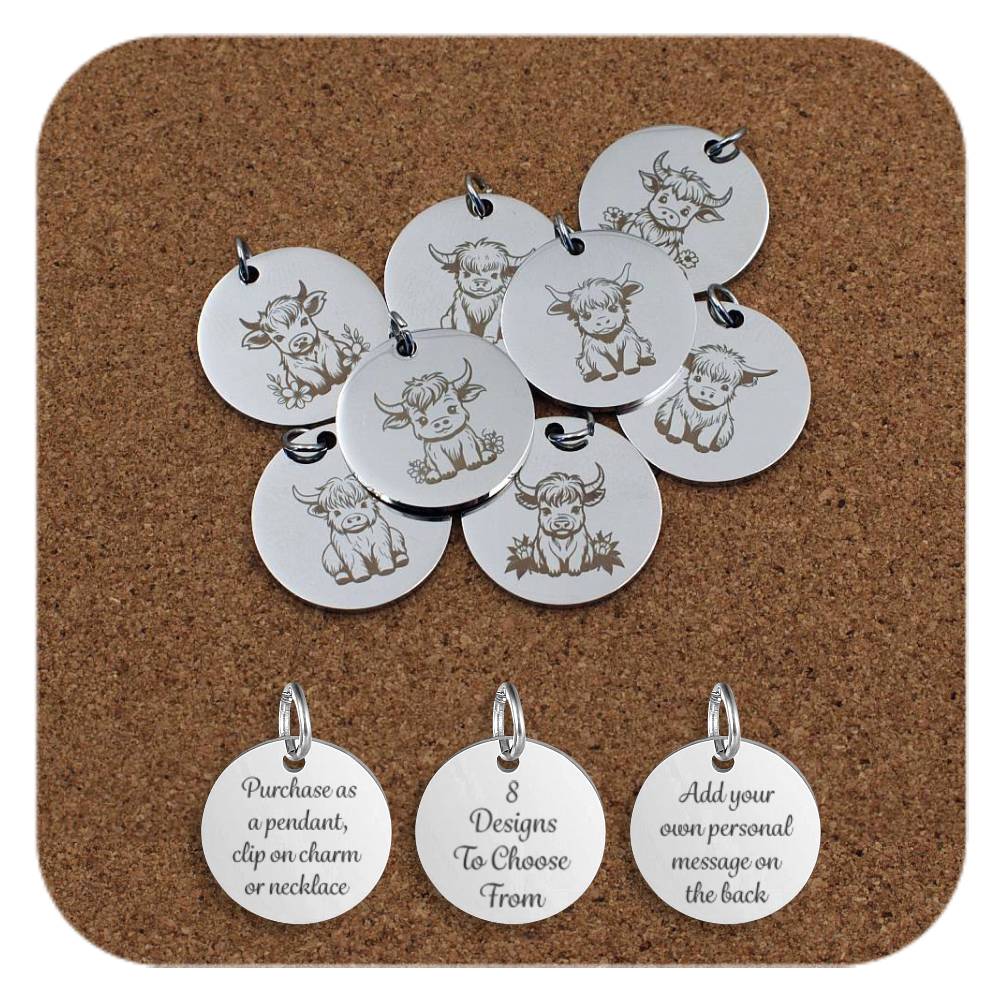Collection of round silver metal pendants engraved with various cute Highland cow designs, displayed on a cork board. Each pendant features a different cow illustration, some with flowers or leaves surrounding them. Below the pendants are three additional discs engraved with the text: 'Purchase as a pendant, clip on charm or necklace,' '8 Designs To Choose From,' and 'Add your own personal message on the back.'