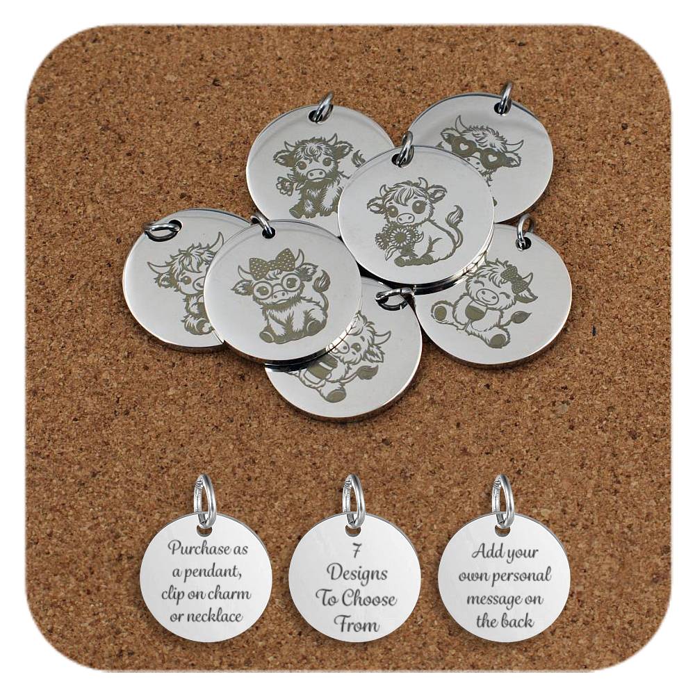 Stainless steel round pendants featuring engraved designs of cute Highland cows in playful and charming poses, arranged on a cork background. Below the pendants are three additional discs showing engraved text that reads: 'Purchase as a pendant, clip on charm or necklace,' '7 Designs To Choose From,' and 'Add your own personal message on the back'