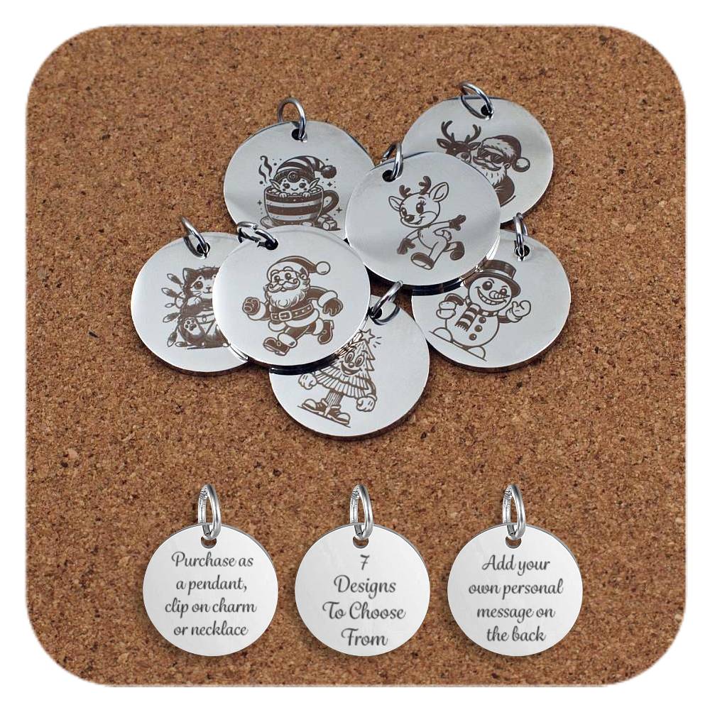 Collection of round silver metal pendants engraved with fun Christmas-themed characters, displayed on a cork board. Designs include Santa Claus, a snowman, a reindeer, a Christmas tree, a Christmas elf in a cup, a reindeer, Santa wearing sunglasses with a reindeer, and a cat tangled in Christmas lights. Below the pendants are three discs engraved with the text: 'Purchase as a pendant, clip on charm or necklace,' '7 Designs To Choose From,' and 'Add your own personal message on the back'
