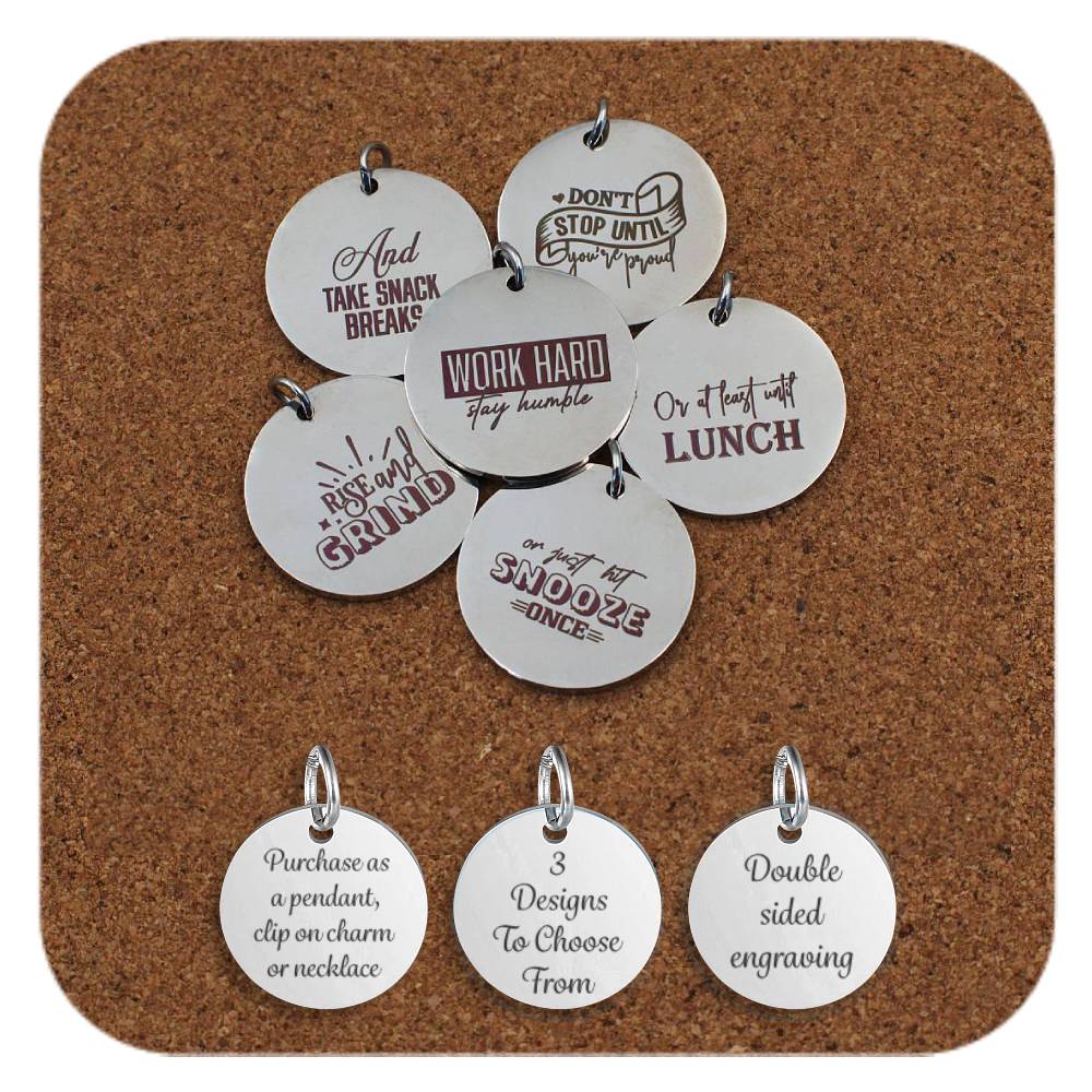 Set of engraved stainless steel pendants arranged on corkboard, each with humorous motivational phrases such as 'Work hard stay humble', 'Don’t stop until you’re proud', 'And take snack breaks', 'Rise & grind', 'Or at least until lunch', and 'Or hit snooze once'. Below, three tags read: 'Purchase as a pendant, clip on charm or necklace', '3 Designs To Choose From', and 'Double sided engraving'.