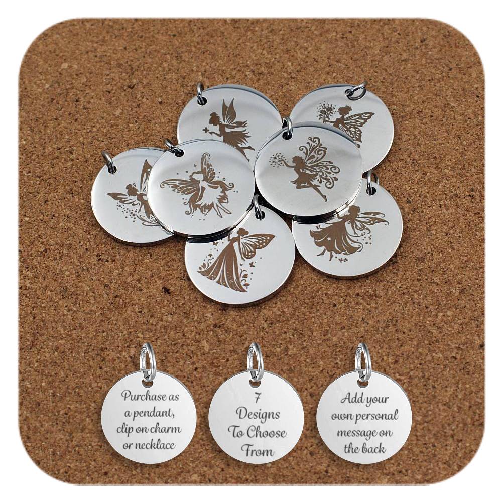 Collection of round silver metal pendants engraved with various fairy designs, displayed on a cork board. Each pendant features a unique illustration of a fairy in different poses with detailed wings, surrounded by stars, flowers, or butterflies. Below the pendants are three additional discs engraved with the text: 'Purchase as a pendant, clip on charm or necklace,' '7 Designs To Choose From,' and 'Add your own personal message on the back.'