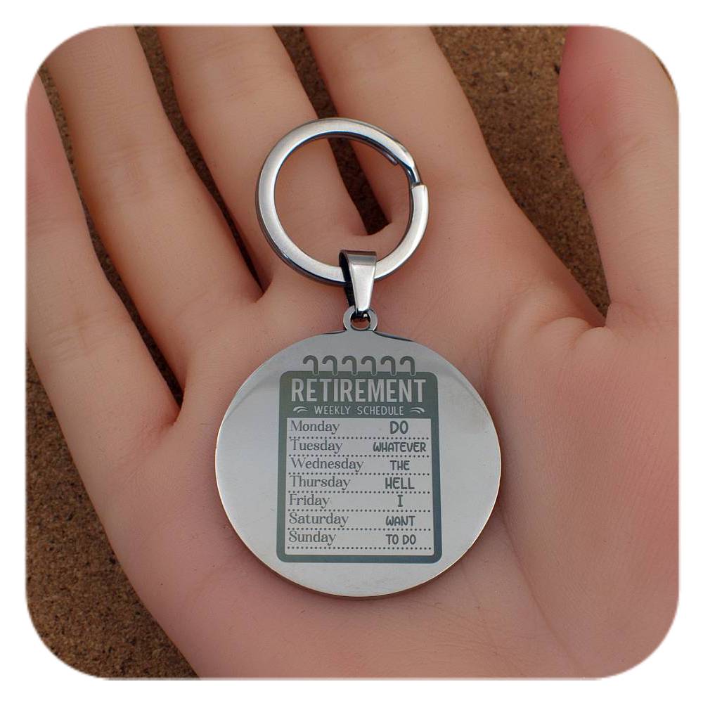 Silver keychain with a round pendant featuring text on a hand.