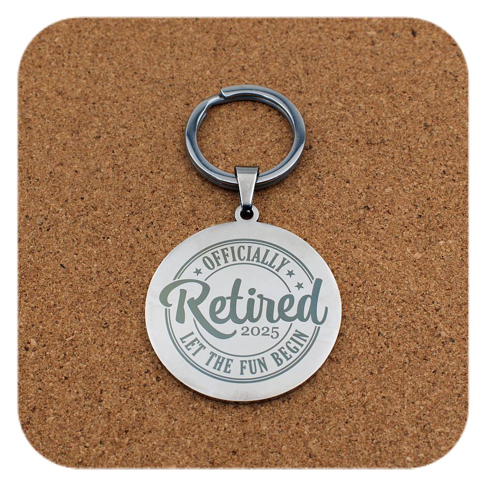 Keychain with 'Officially Retired 2025' text on a cork background