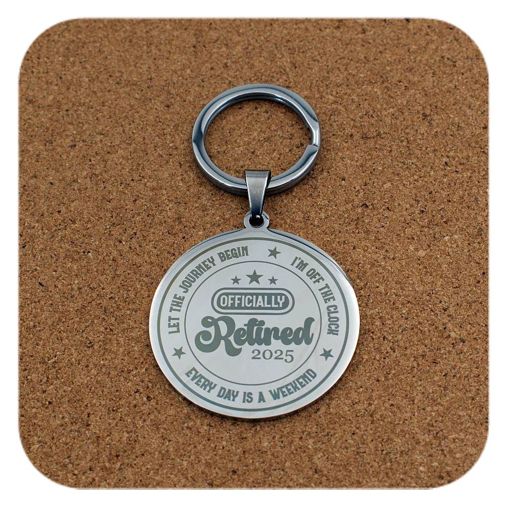 Silver retired 2025 keychain on a brown cork background