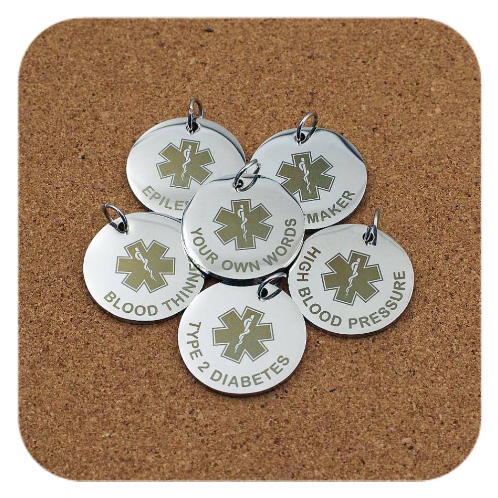 Silver pendants with different Star Of Life Emergency ID designs on cork background