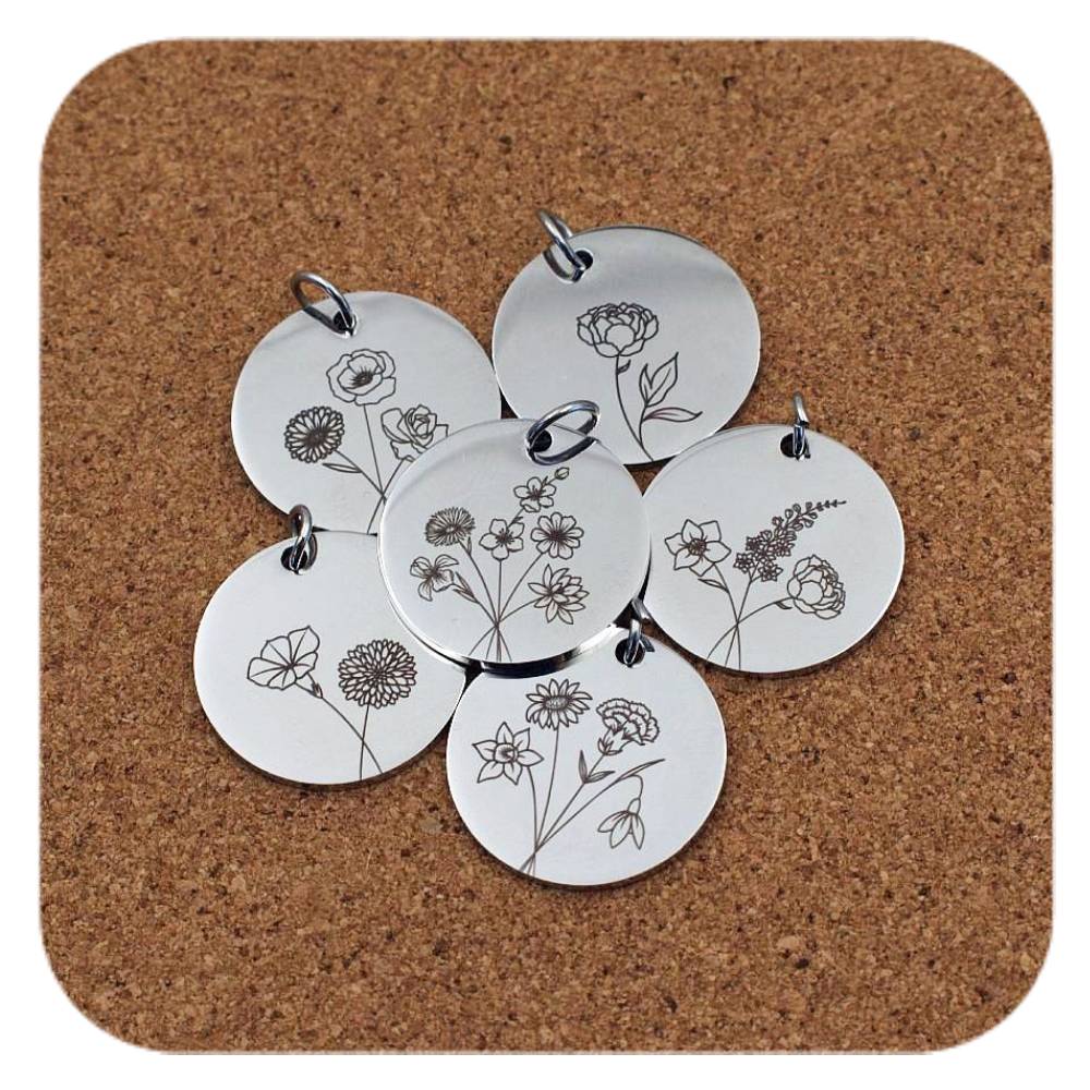 Silver pendants with different Floral Birth Flower designs on cork background