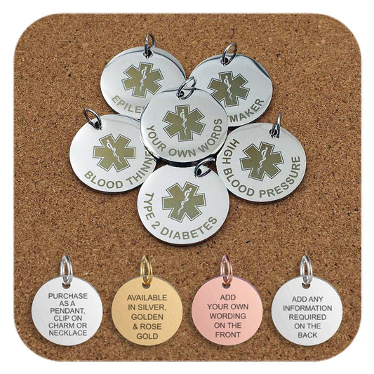 Collection of round metal medical alert pendants displayed on a corkboard featuring engraved medical symbols and text such as 'Epilepsy', 'Pacemaker', 'Blood Thinner', 'Type 2 Diabetes', 'High Blood Pressure', and 'Your Own Words' for custom engraving. Four additional pendants at the bottom show engraved text that reads: pendant or charm use, metal finishes in silver, gold, and rose gold, and the ability to add personalized wording on the front and back.