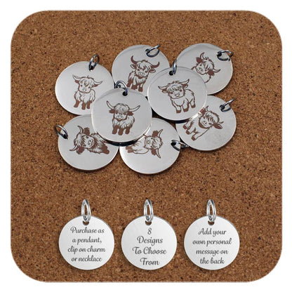 Selection of round silver metal pendants engraved with various Highland cow designs, displayed on a cork board. Each pendant features a different illustration of a Highland cow in various poses and expressions, with detailed horns and shaggy hair. Below the pendants are three additional discs engraved with the text: 'Purchase as a pendant, clip on charm or necklace,' '8 Designs To Choose From,' and 'Add your own personal message on the back.'