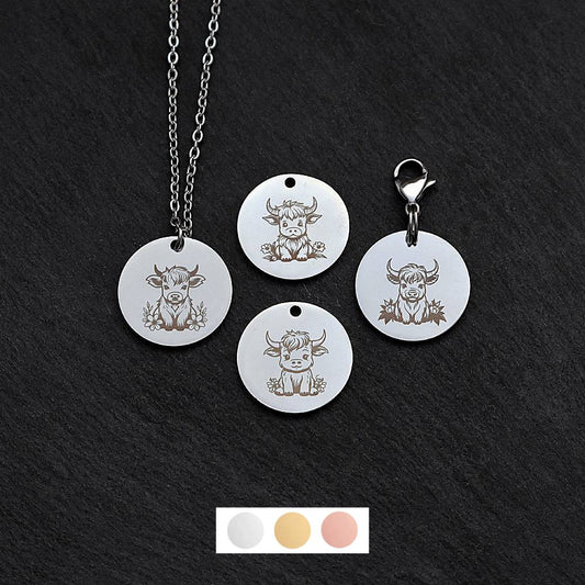 Four silver round disc pendants on a black slate background showing four different highland cow designs. One has a silver necklace attached by a jump ring and another has a lobster clasp and split ring attached to it