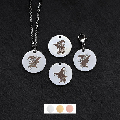 Four silver round disc pendants on a black slate background showing four different witch heads wearing a witch hat designs. One has a silver necklace attached by a jump ring and another has a lobster clasp and split ring attached to it