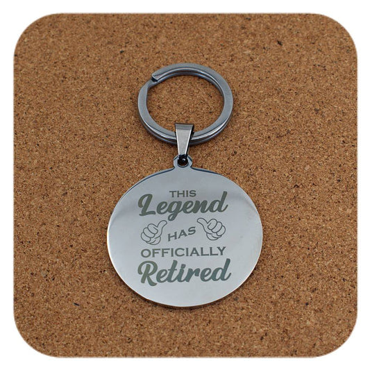 Silver keychain with engraved text on a cork background