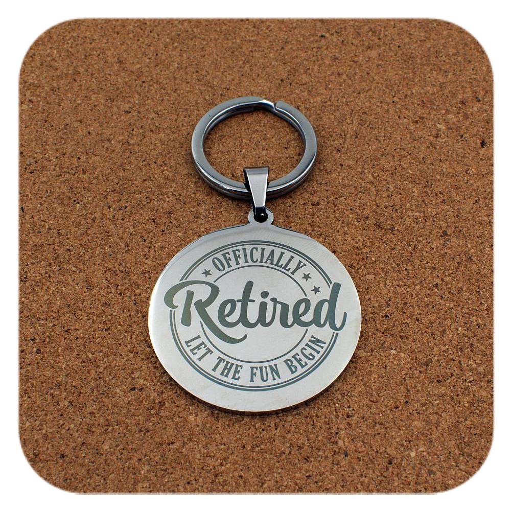 Silver keyring with Retired Let The Fun Begin design on cork background