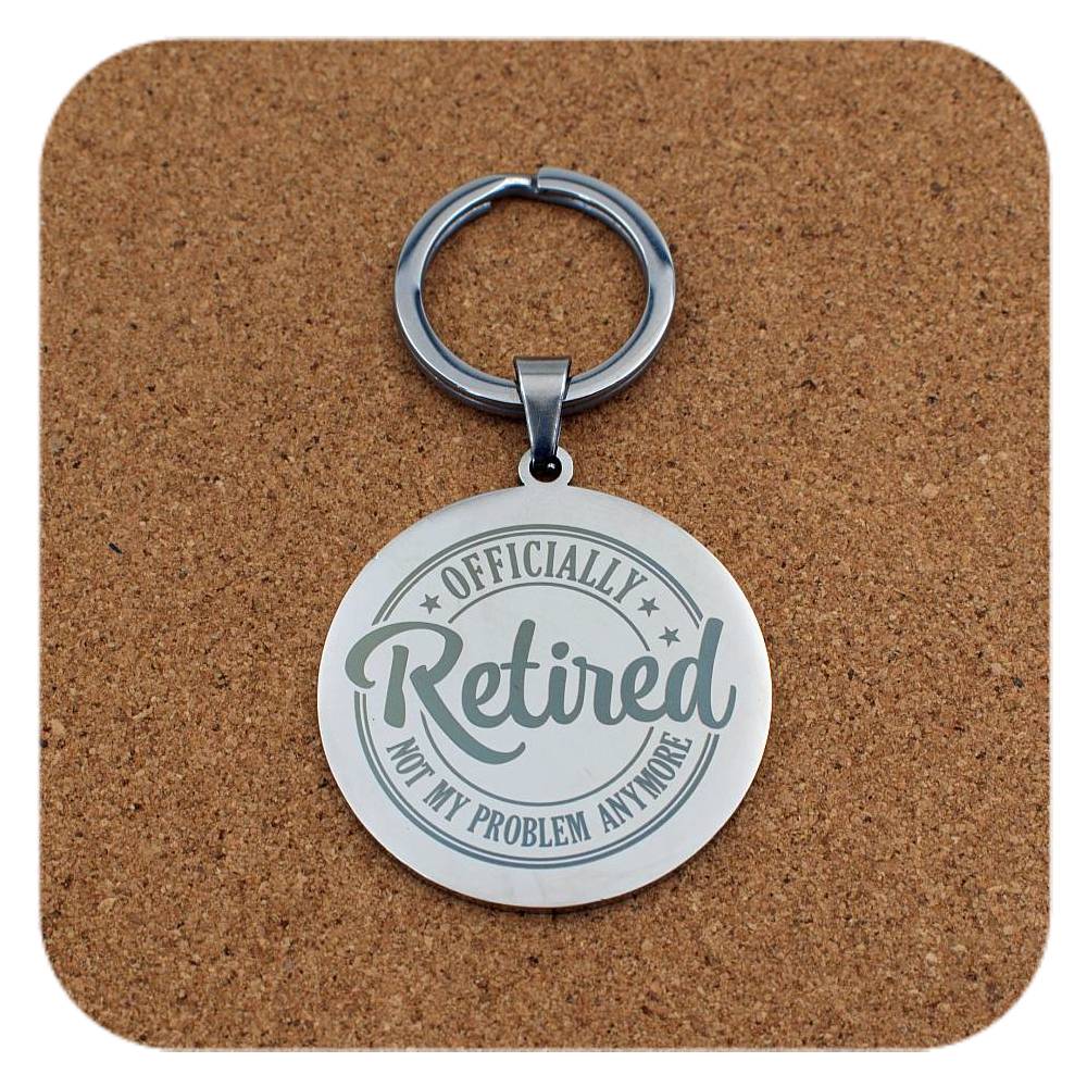 Keychain with 'Officially Retired, Not My Problem Anymore' text on a cork background