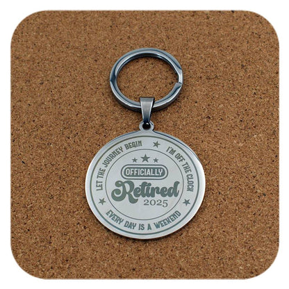 Silver retired 2025 keychain on a brown cork background