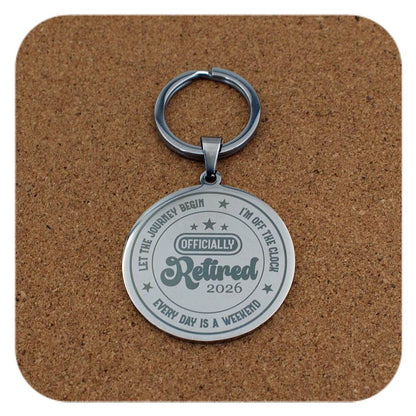 Keychain with 'Officially Retired 2026' text on a cork background