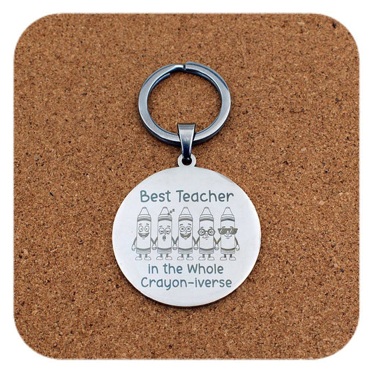 Silver keyring with Best Teacher In Crayon-iverse design on cork background