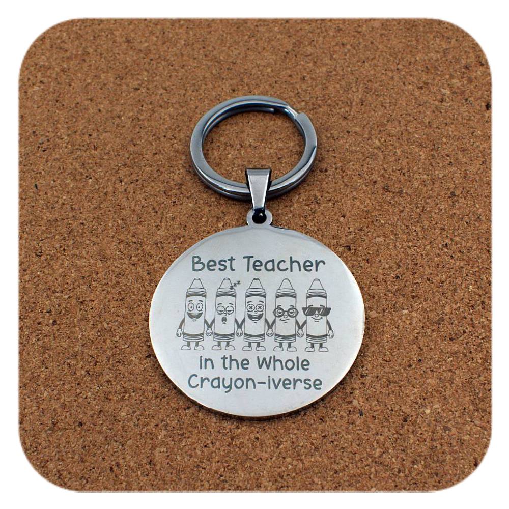 Silver keyring with Best Teacher In Crayon-iverse design on cork background