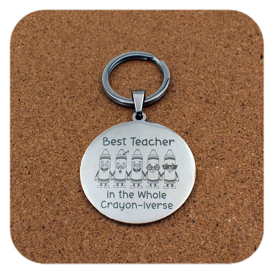 Silver keyring with Best Teacher In Crayon-iverse design on cork background