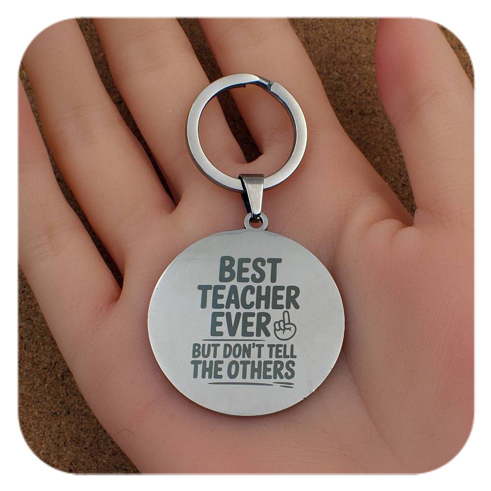 Silver keyring with Best Teacher Don't Tell Others design held in a hand