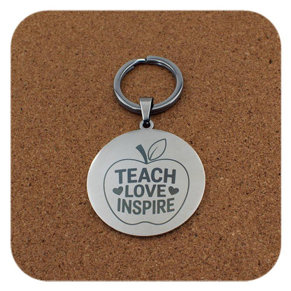 Silver keyring with Teach Love Inspire Apple design on cork background