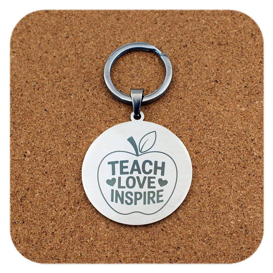 Silver keyring with Teach Love Inspire Apple design on cork background