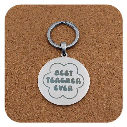 Silver keyring with Best Teacher Ever Flower design on cork background