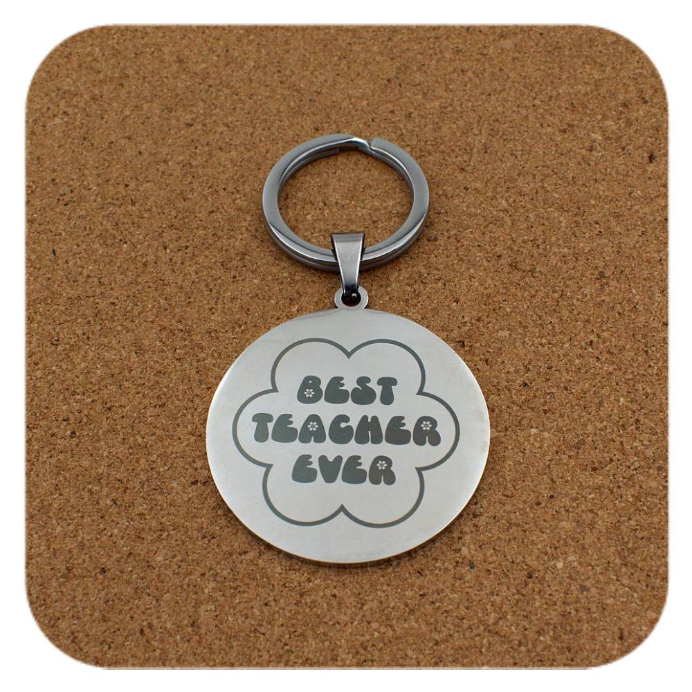 Silver keyring with Best Teacher Ever Flower design on cork background
