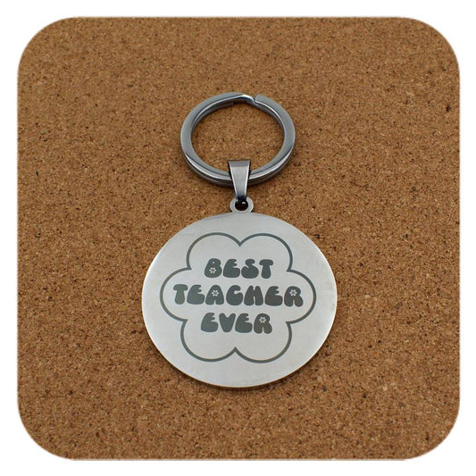 Silver keyring with Best Teacher Ever Flower design on cork background