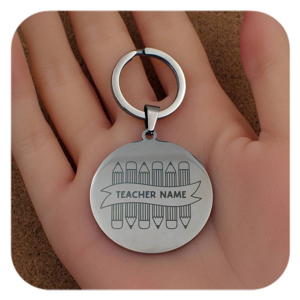 Silver keyring with Crayons With Teachers Name design held in a hand