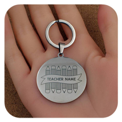 Silver keyring with Crayons With Teachers Name design held in a hand