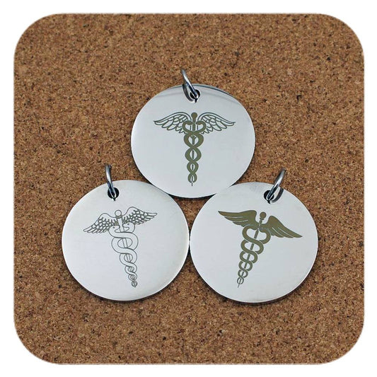 Silver pendants with different Caduceus Medical ID designs on cork background