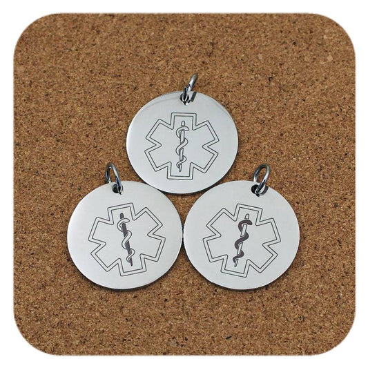 Silver pendants with different Star Of Life Medical ID designs on cork background