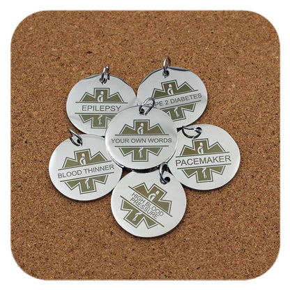 Silver pendants with different Medical ID Star Of Life designs on cork background
