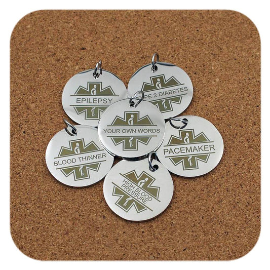 Silver pendants with different Medical ID Star Of Life designs on cork background
