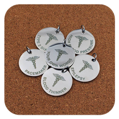 Silver pendants with different Caduceus Symbol Emergency ID designs on cork background