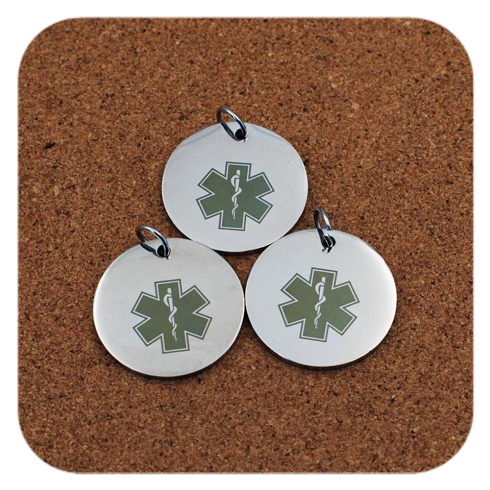 Silver pendants with different Star Of Life Medical ID designs on cork background