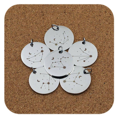 Silver pendants with different Celestial Star Sign designs on cork background