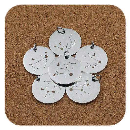Silver pendants with different Celestial Star Sign designs on cork background