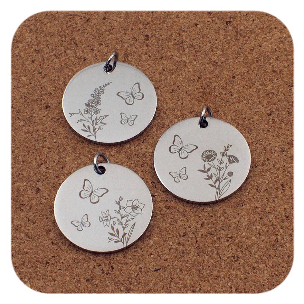 Silver pendants with different Birth Flower Butterfly designs on cork background