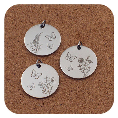 Silver pendants with different Birth Flower Butterfly designs on cork background