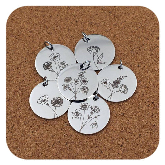 Silver pendants with different Floral Birth Flower designs on cork background