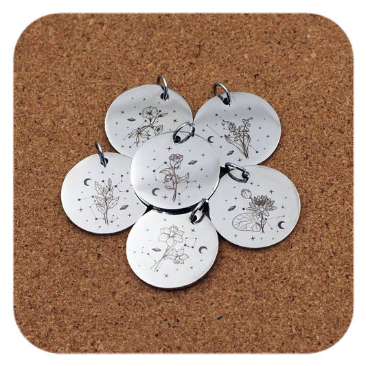 Silver pendants with different Celestial Birth Flower designs on cork background