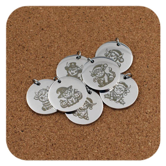 Silver pendants with different Highland Cow designs on cork background