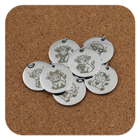 Silver pendants with different Cute & Sassy Highland Cow designs on cork background