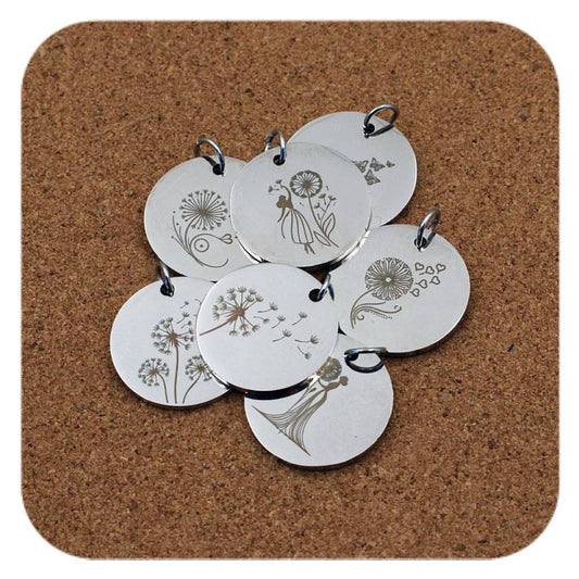 Silver pendants with different Dandelion Wish designs on cork background
