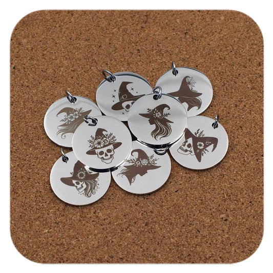 Silver pendants with different Enchanted Witch designs on cork background