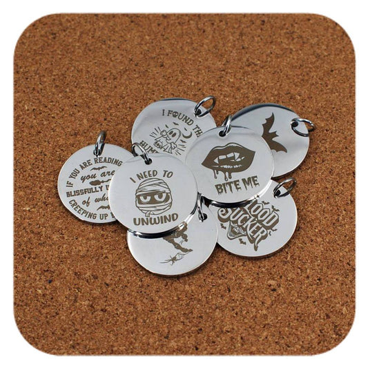 Silver pendants with different Halloween Vibes designs on cork background