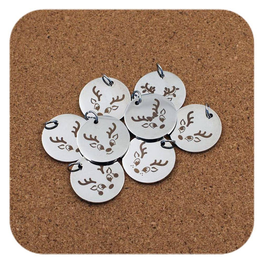 Silver pendants with different Cute Reindeer Head designs on cork background
