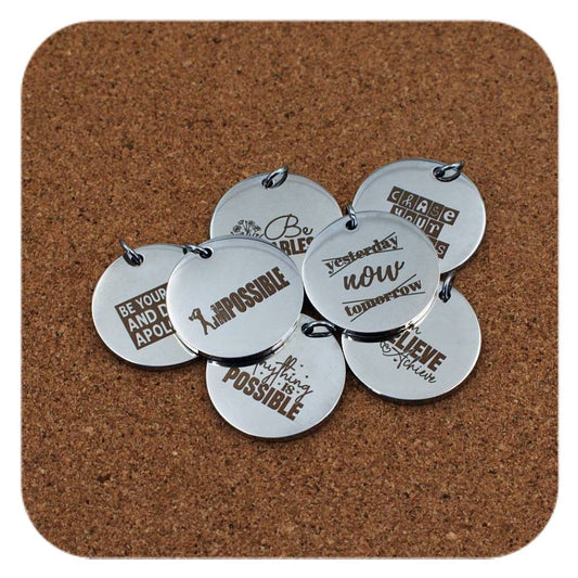Silver pendants with different Motivational Quote designs on cork background